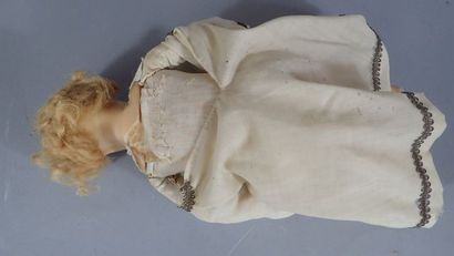 Poupon en cire assis vêtu d'une robe en tissu...
