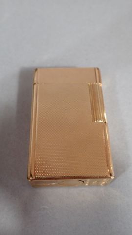 DUPONT. Briquet en métal doré à décor guilloché....