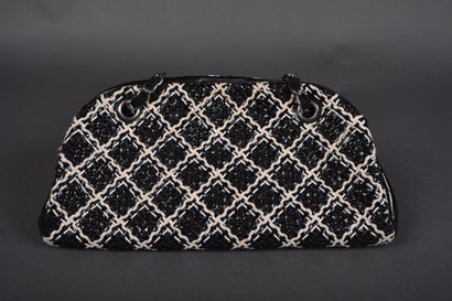 CHANEL
Black patent leather bag quilted on...