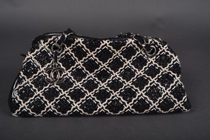 CHANEL
Black patent leather bag quilted on...