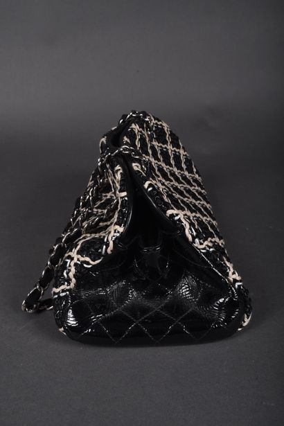 CHANEL
Black patent leather bag quilted on...