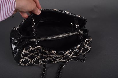 CHANEL
Black patent leather bag quilted on...