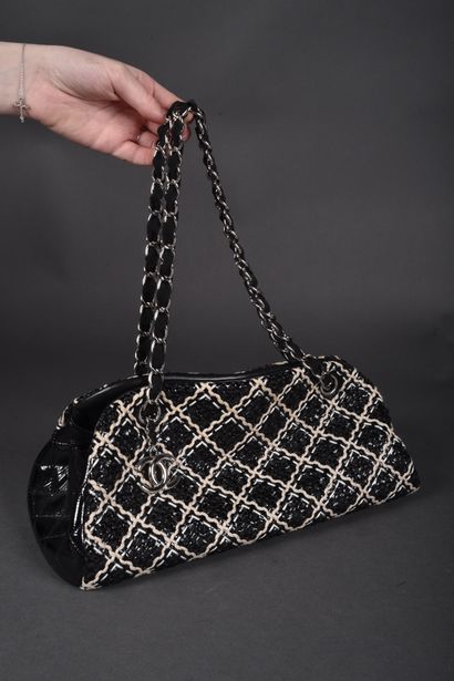CHANEL
Black patent leather bag quilted on...