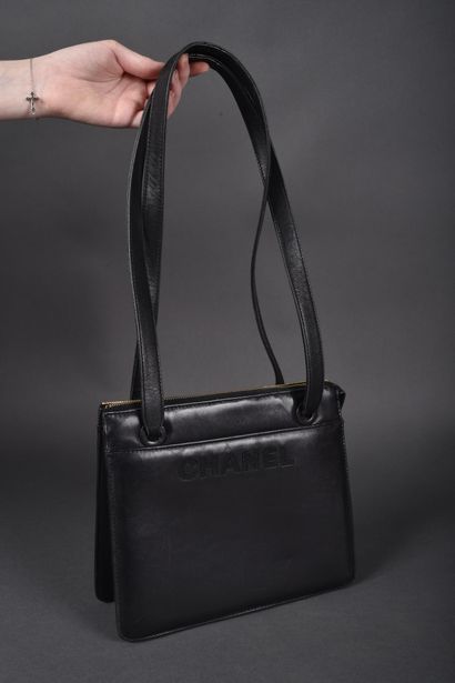 CHANEL circa 1990
Rigid black leather bag...