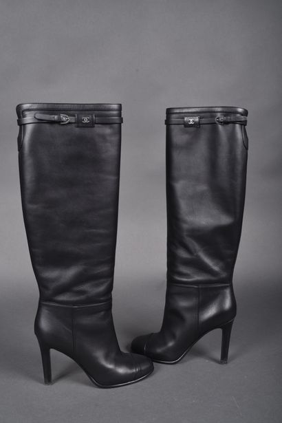 CHANEL
Pair of black leather boots, strap...