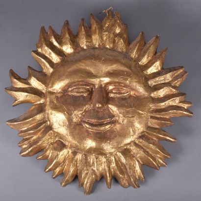 Large sun with smiling human face in gilded...