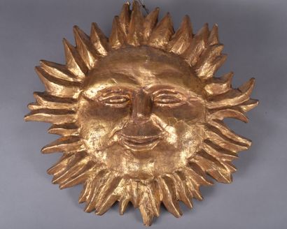 Large sun with smiling human face in gilded...