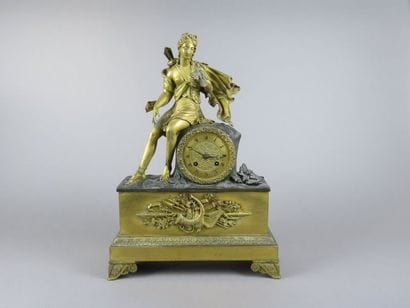 Pendule en bronze doré et patiné. Le mouvement...