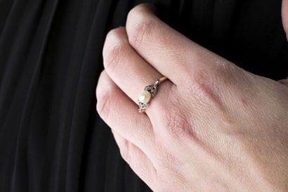 Bague en or jaune ornée au centre d'une perle...
