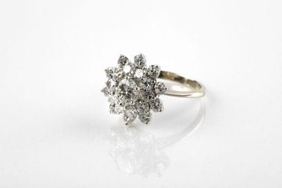 Bague marguerite en or gris retenant un diamant...