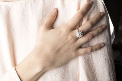 Bague marguerite en or gris retenant un diamant...