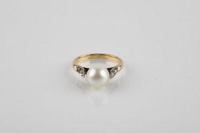 Yellow and white gold ring adorned with an...