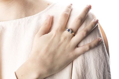Yellow gold daisy ring holding an oval cut...