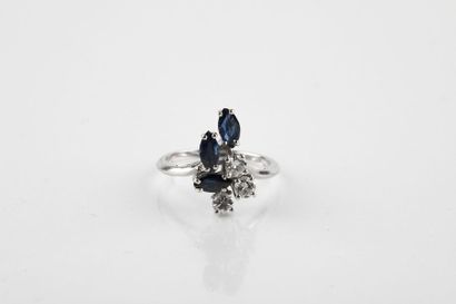 White gold ring adorned with three shuttle-cut...