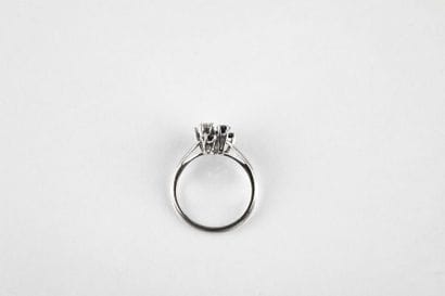 White gold ring adorned with three shuttle-cut...