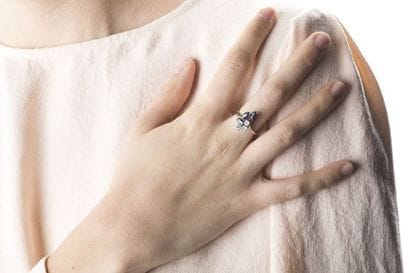 White gold ring adorned with three shuttle-cut...