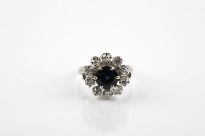 White gold ring adorned in the center with...
