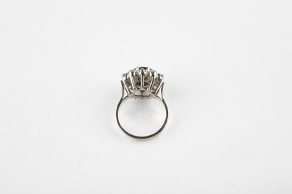 White gold ring adorned in the center with...