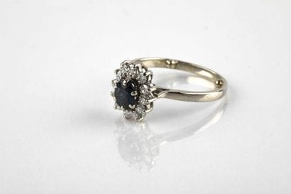 White gold daisy ring holding an oval-cut...