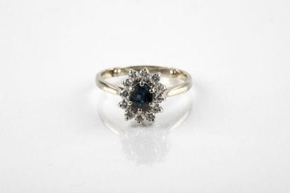 White gold daisy ring holding an oval-cut...