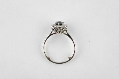 White gold daisy ring holding an oval-cut...