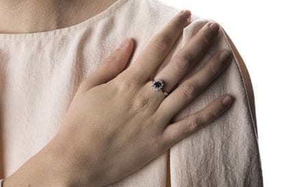White gold daisy ring holding an oval-cut...