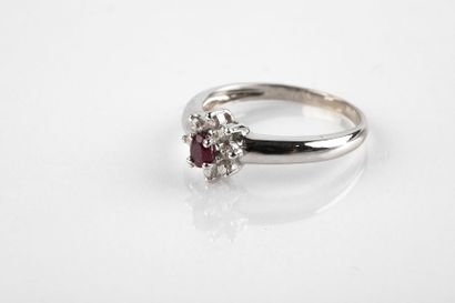 White gold ring holding an oval cut ruby...