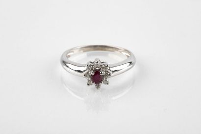 White gold ring holding an oval cut ruby...
