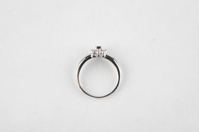 White gold ring holding an oval cut ruby...