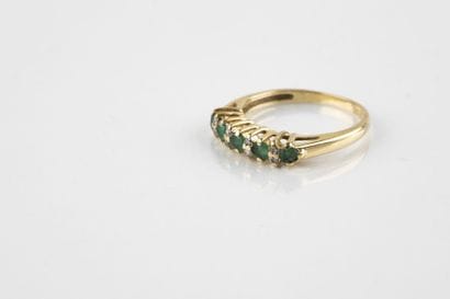 A yellow gold half wedding ring adorned with...