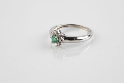 White gold ring holding an oval cut emerald...