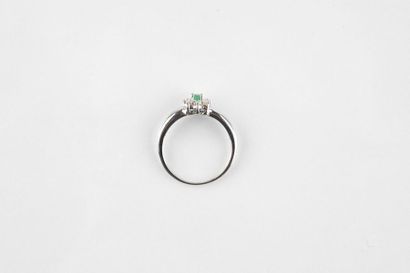 White gold ring holding an oval cut emerald...