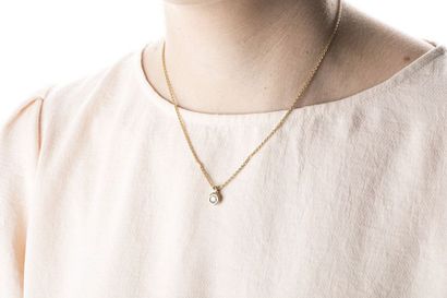 Yellow gold palm mesh necklace holding a...