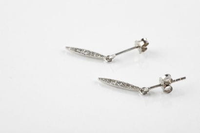 Pair of hanging earrings, in white gold holding...