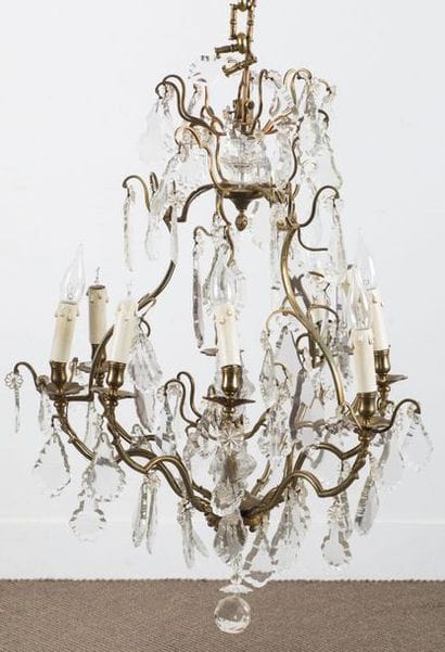 Lustre en bronze à neuf bras de lumière arqués....