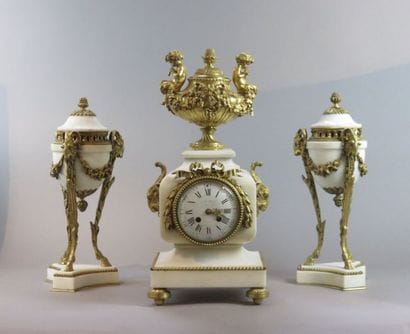 Pendule et paire de cassolettes en marbre...