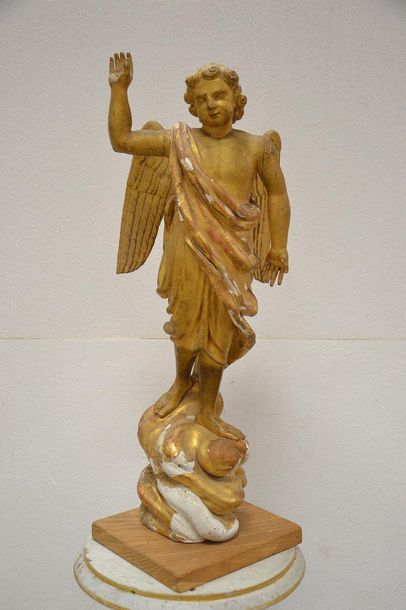 Carved and gilded wooden cherub. Standing...