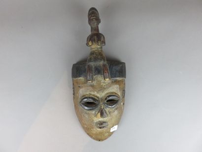 MASQUE FACIAL surmonté d’une statuette féminine...