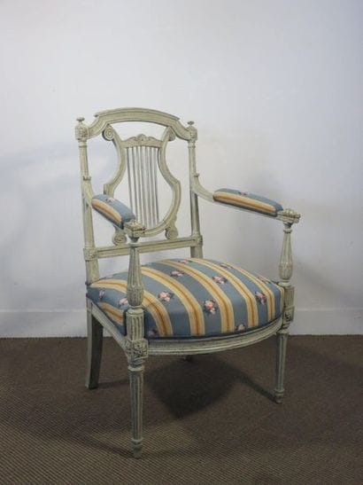 Fauteuil en bois laqué gris mouluré et sculpté....