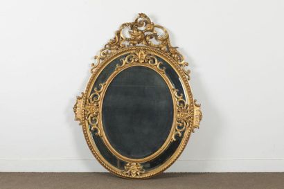 Miroir ovale en bois et stuc doré à parecloses...