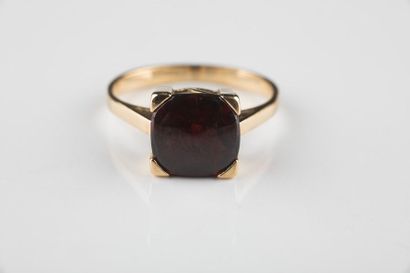 Bague en or jaune ornée d’un grenat swiffé....