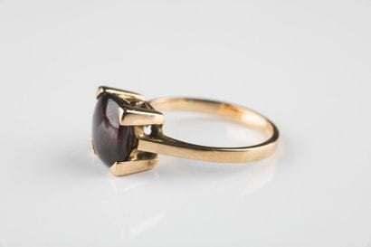 Bague en or jaune ornée d’un grenat swiffé....