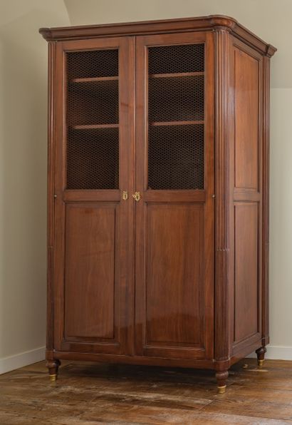 Armoire bibliothèque en acajou. Elle ouvre...
