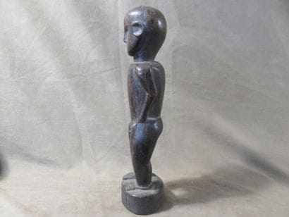 Statuette représentée debout les mains posées...