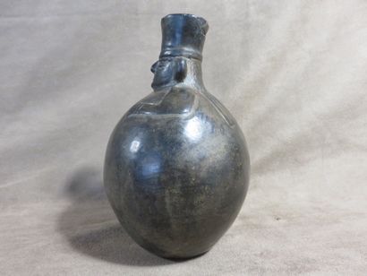 Vase boule surmonté d’une tête de personnage....