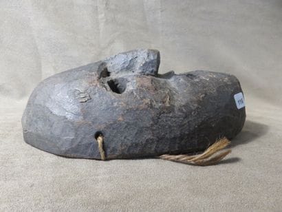 Mask of oval shape. Dark grey terracotta....