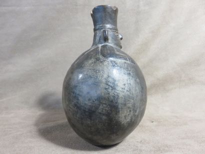 Vase boule surmonté d’une tête de personnage....