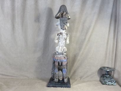 Male statue. The figure is depicted sitting...
