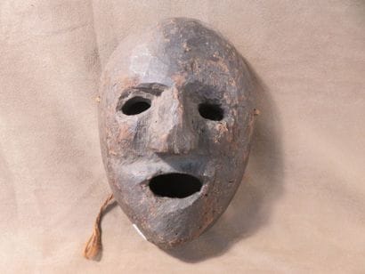 Mask of oval shape. Dark grey terracotta....