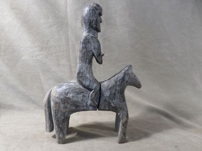 Statue of a man on horseback. Wood with grey...